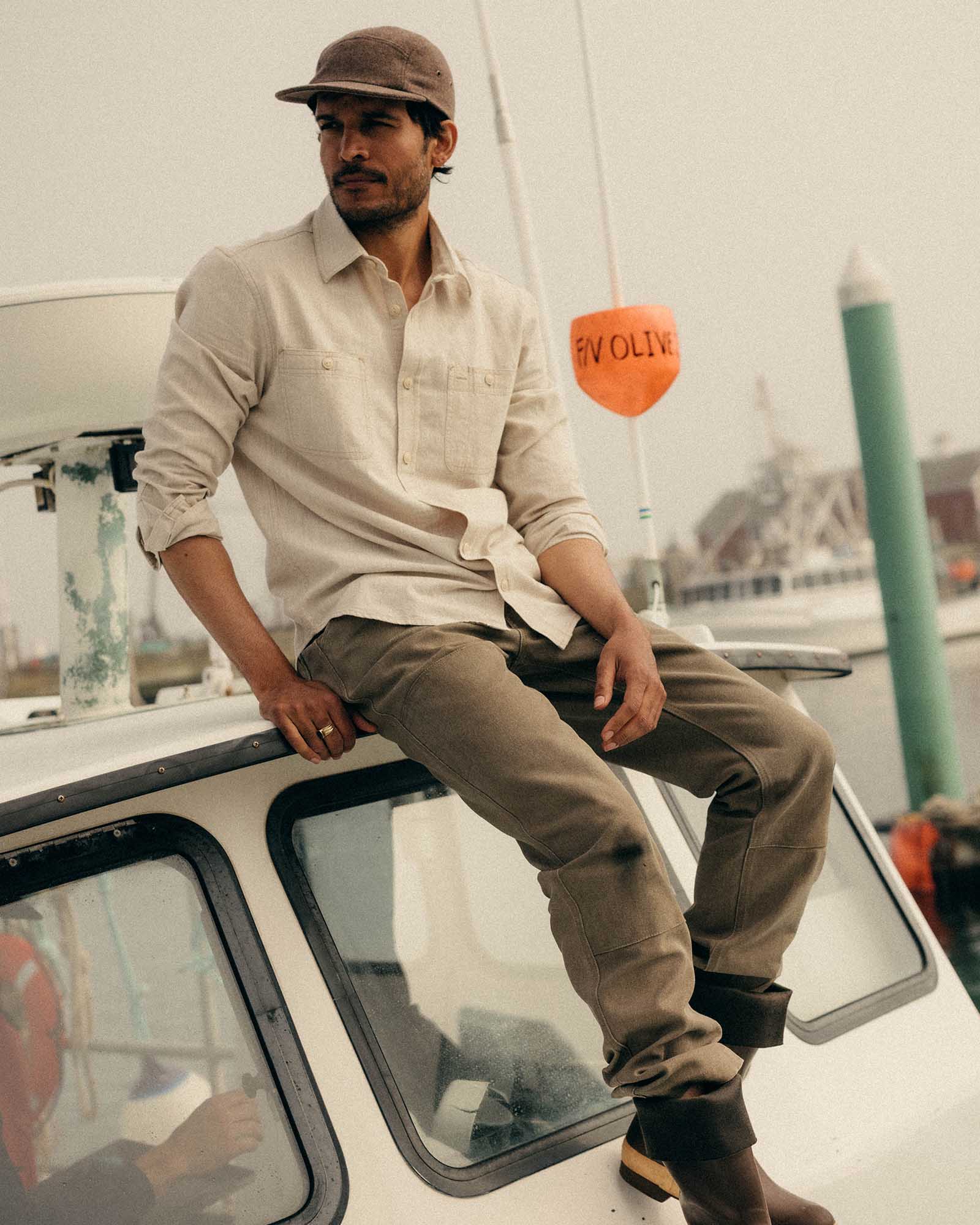 fit model sitting wearing The Foundry Shirt in Natural Chambray, Wovens by Taylor Stitch