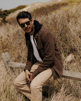 fit model sitting wearing The Ledge Shirt in Black Coffee Linen Tweed, Wovens by Taylor Stitch