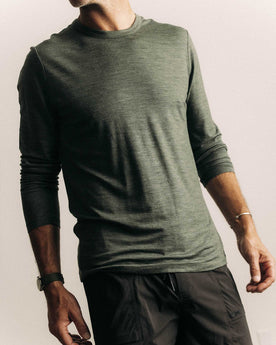fit model posing in The Merino Long Sleeve Tee in Heather Army, Knits by Taylor Stitch