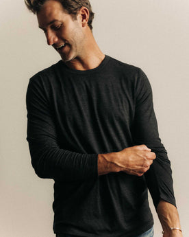 fit model posing in The Merino Long Sleeve Tee in Heather Black, Knits by Taylor Stitch