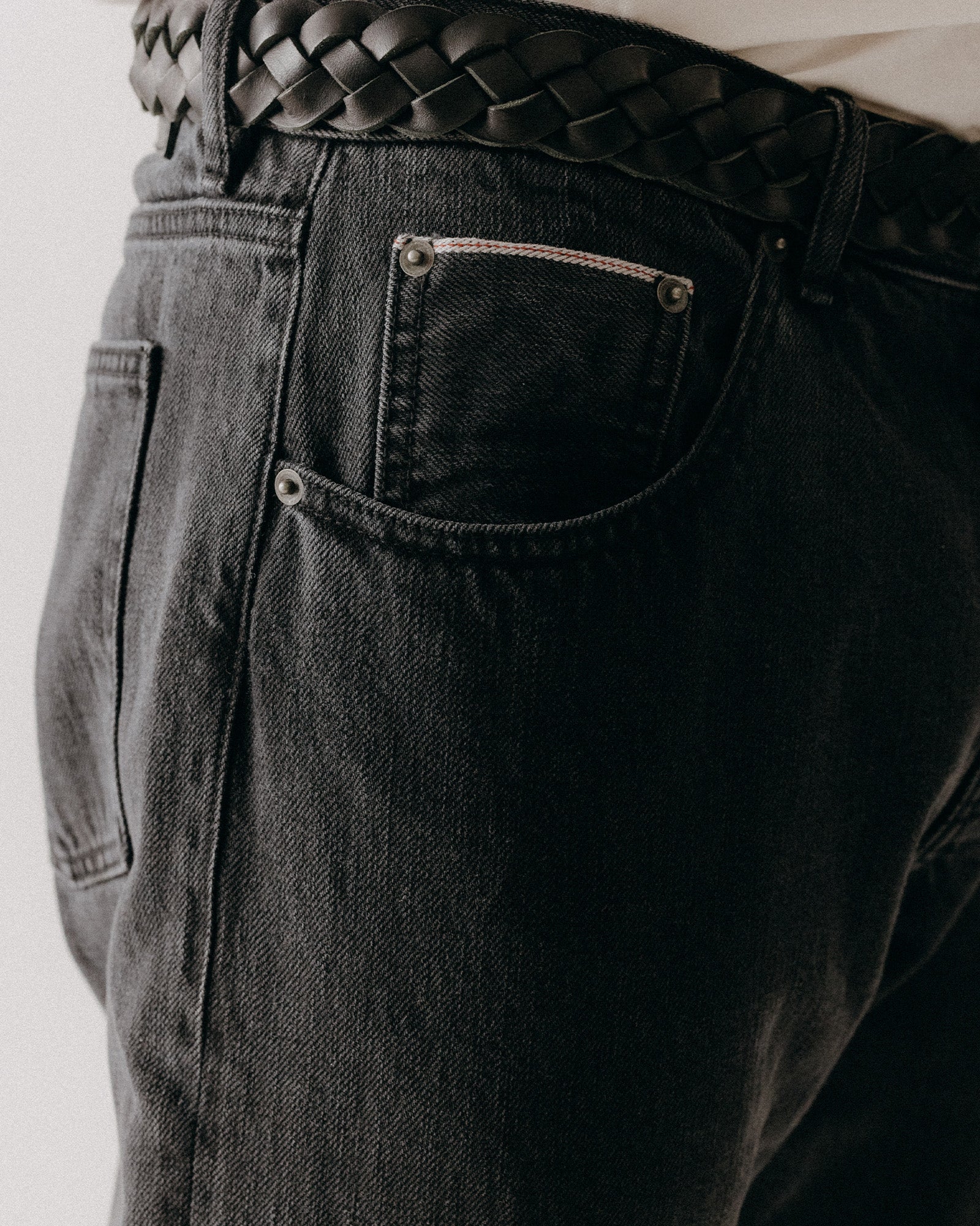 fit model showing off the pocket on The Democratic Jean in Washed Black Organic Slub Selvedge, Bottoms by Taylor Stitch