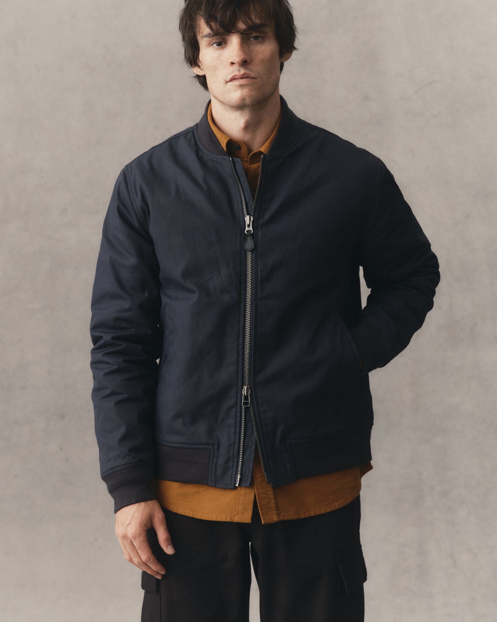 fit model posing in The Insulated Bomber Jacket in Dark Navy Dry Wax, Outerwear by Taylor Stitch