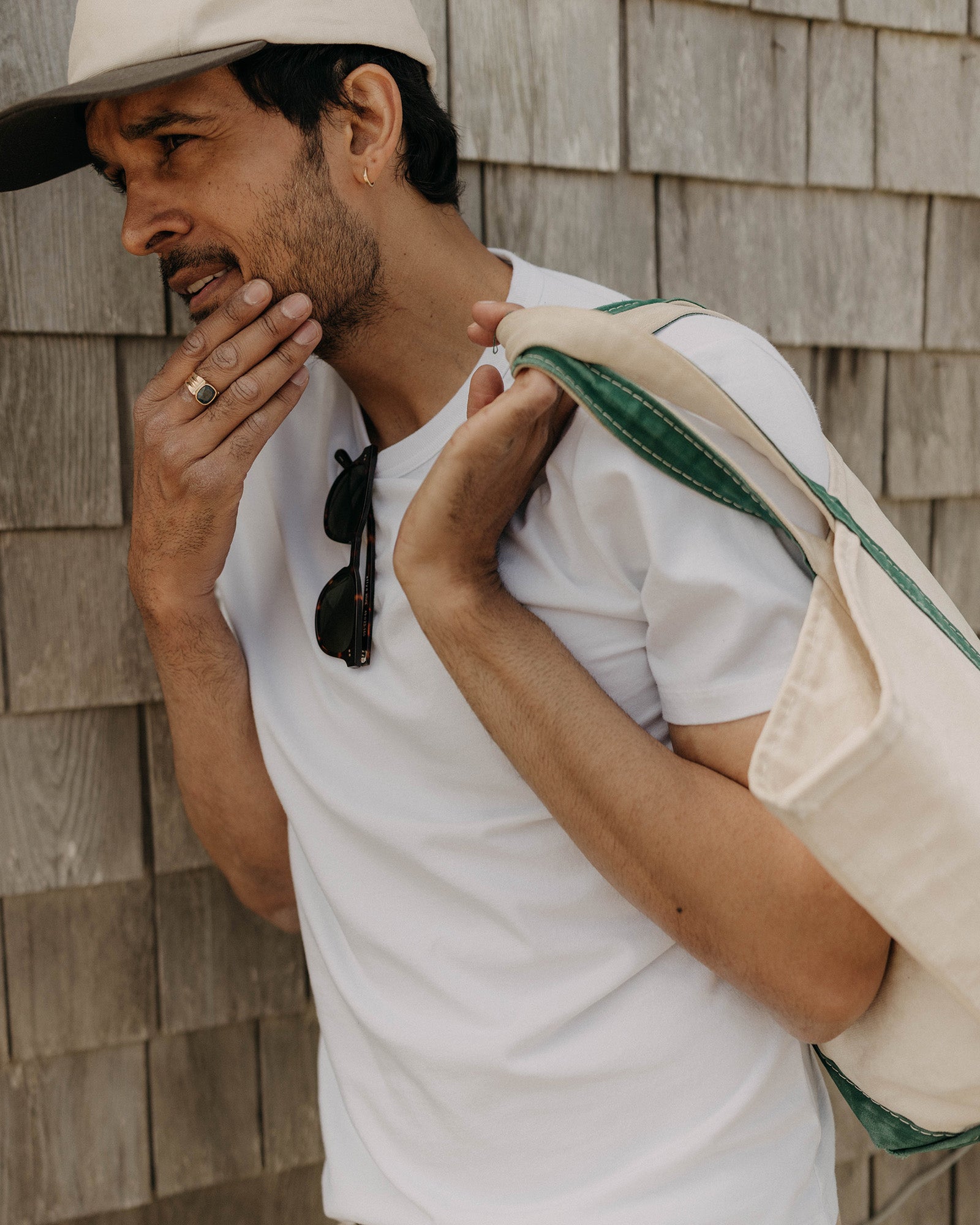 fit model leaning against the wall wearing The Organic Cotton Tee in White, Knits by Taylor Stitch