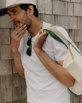 fit model leaning against the wall wearing The Organic Cotton Tee in White, Knits by Taylor Stitch