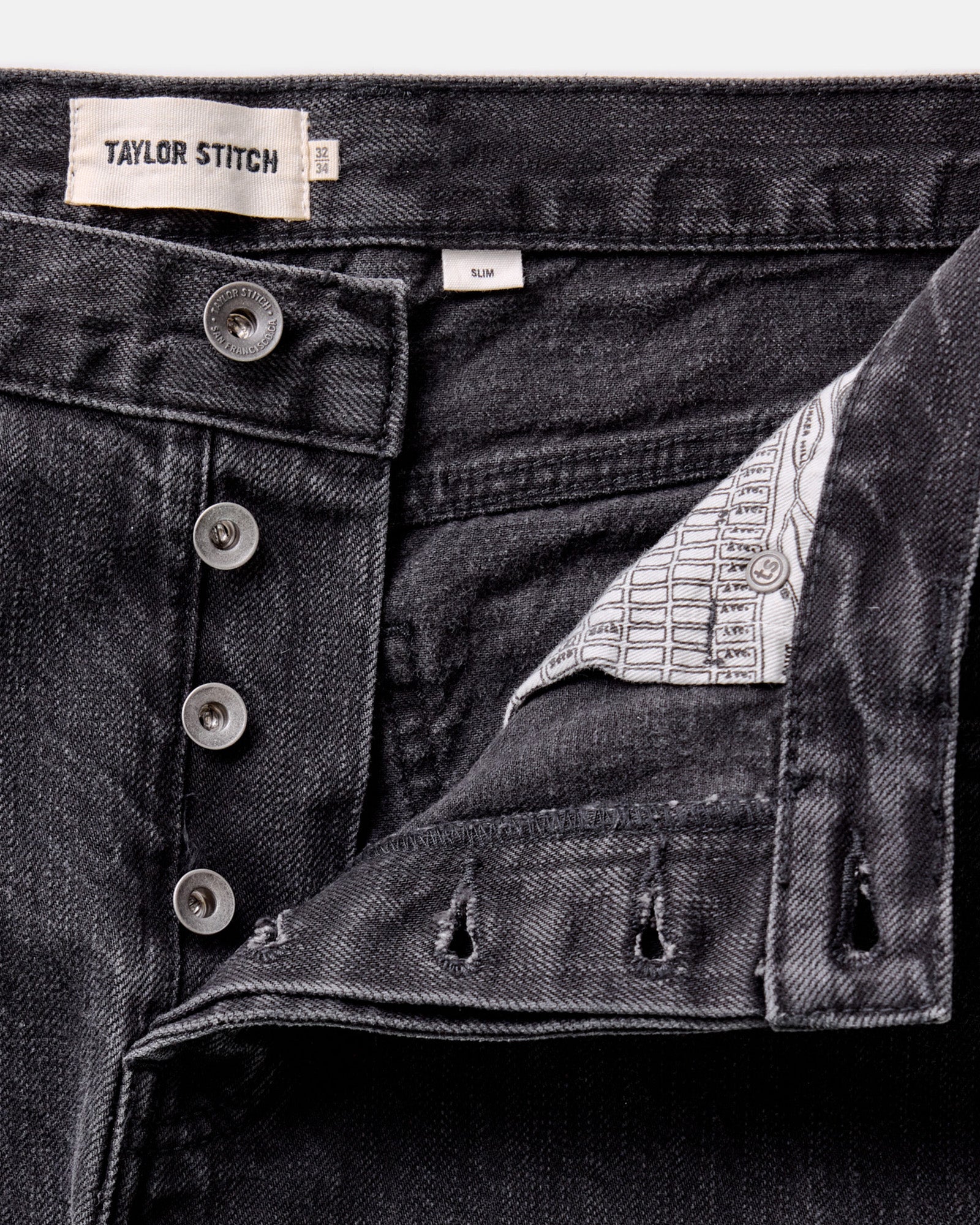 material shot of the button fly on The Slim Jean in Washed Black Organic Slub Selvedge, Bottoms by Taylor Stitch
