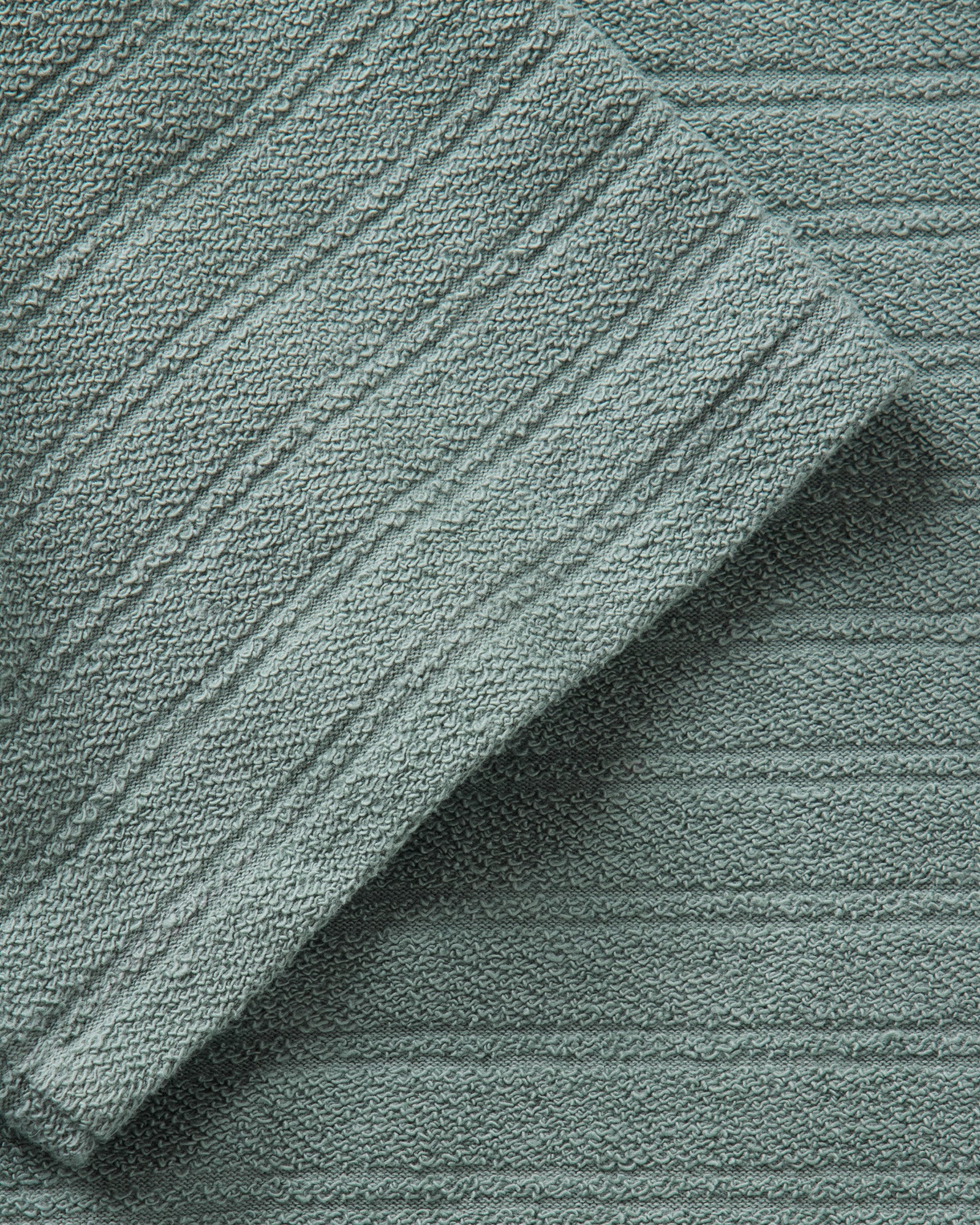 material shot of the sleeve on The Meridian Polo in Faded Pine, Knits by Taylor Stitch