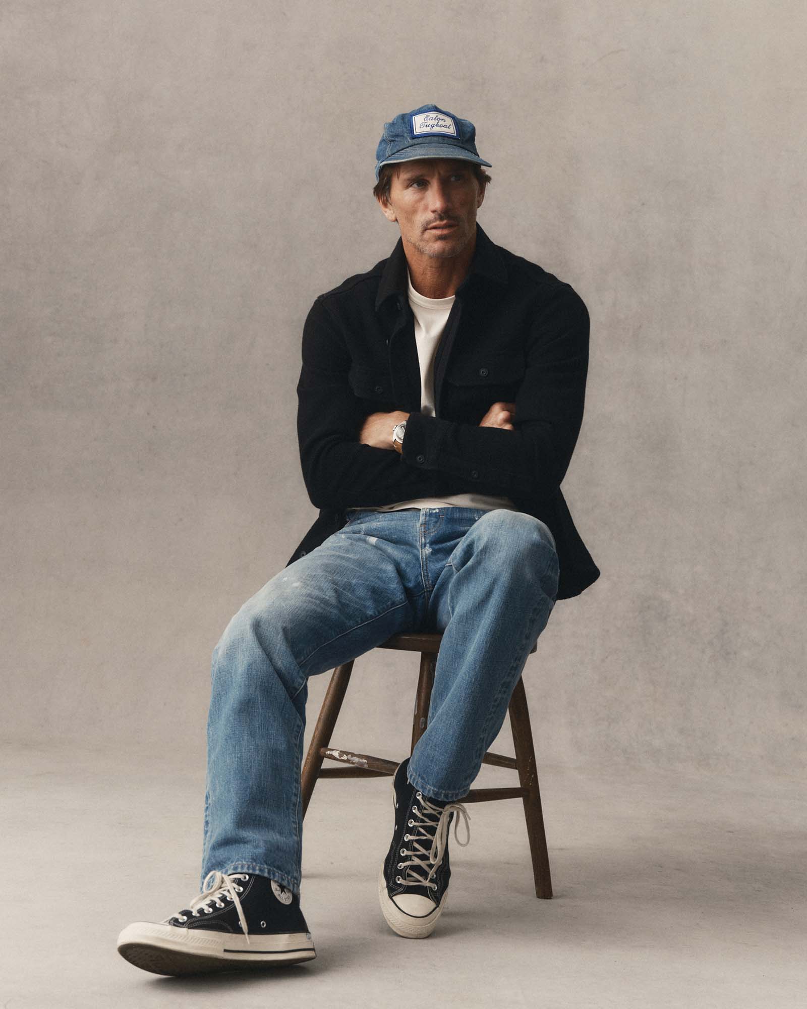 fit model sitting wearing The Division Shirt in Black Indigo, Wovens by Taylor Stitch