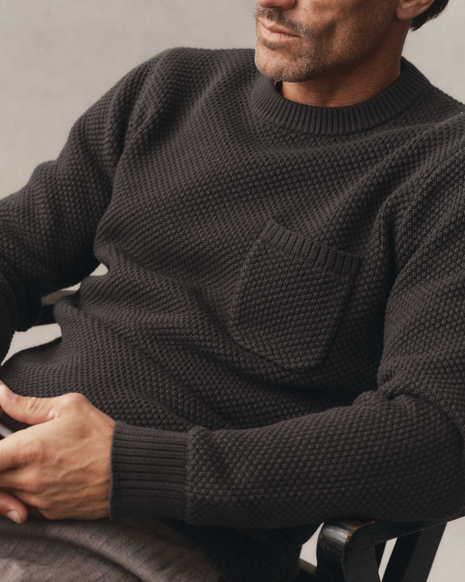fit model sitting wearing The Crawford Crew Sweater in Charcoal, Sweaters by Taylor Stitch