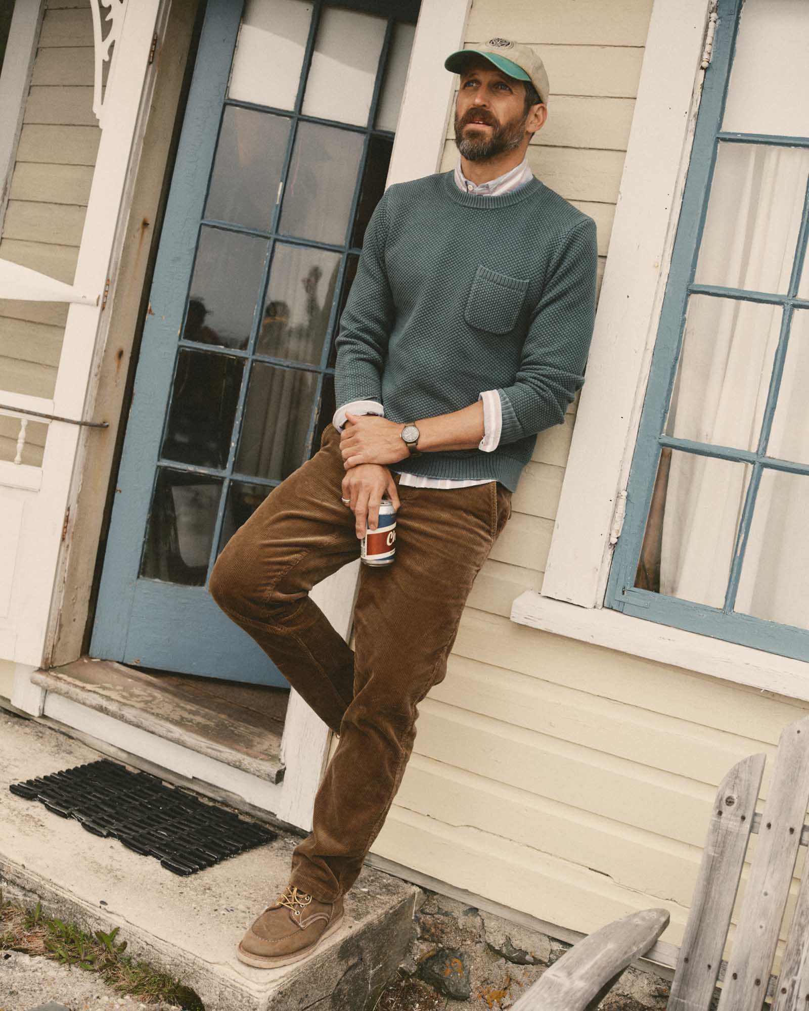 fit model leaning against the wall wearing The Crawford Crew Sweater in Faded Spruce, Knits by Taylor Stitch