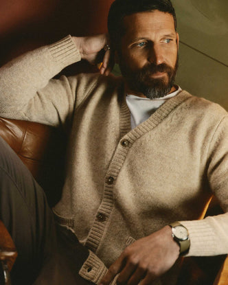 fit model sitting wearing The Eastmoor Cardigan in Oatmeal Wool