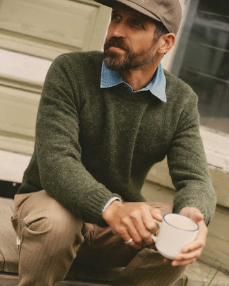 fit model sitting wearing The Eastmoor Sweater in Spruce Wool