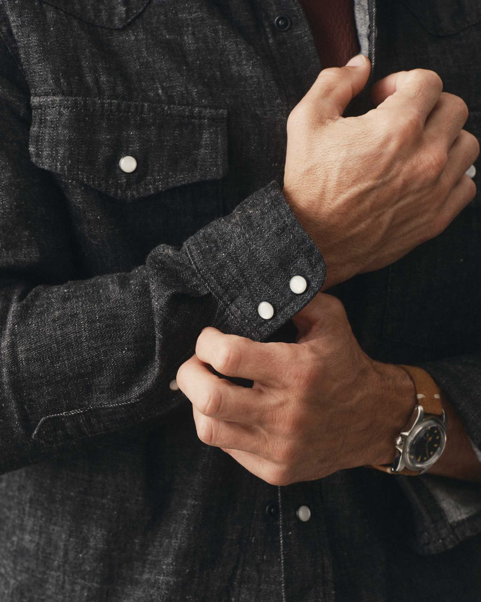 fit model adjusting the cuff on The Glacier Shirt in Black Indigo Hemp Denim, Wovens by Taylor Stitch