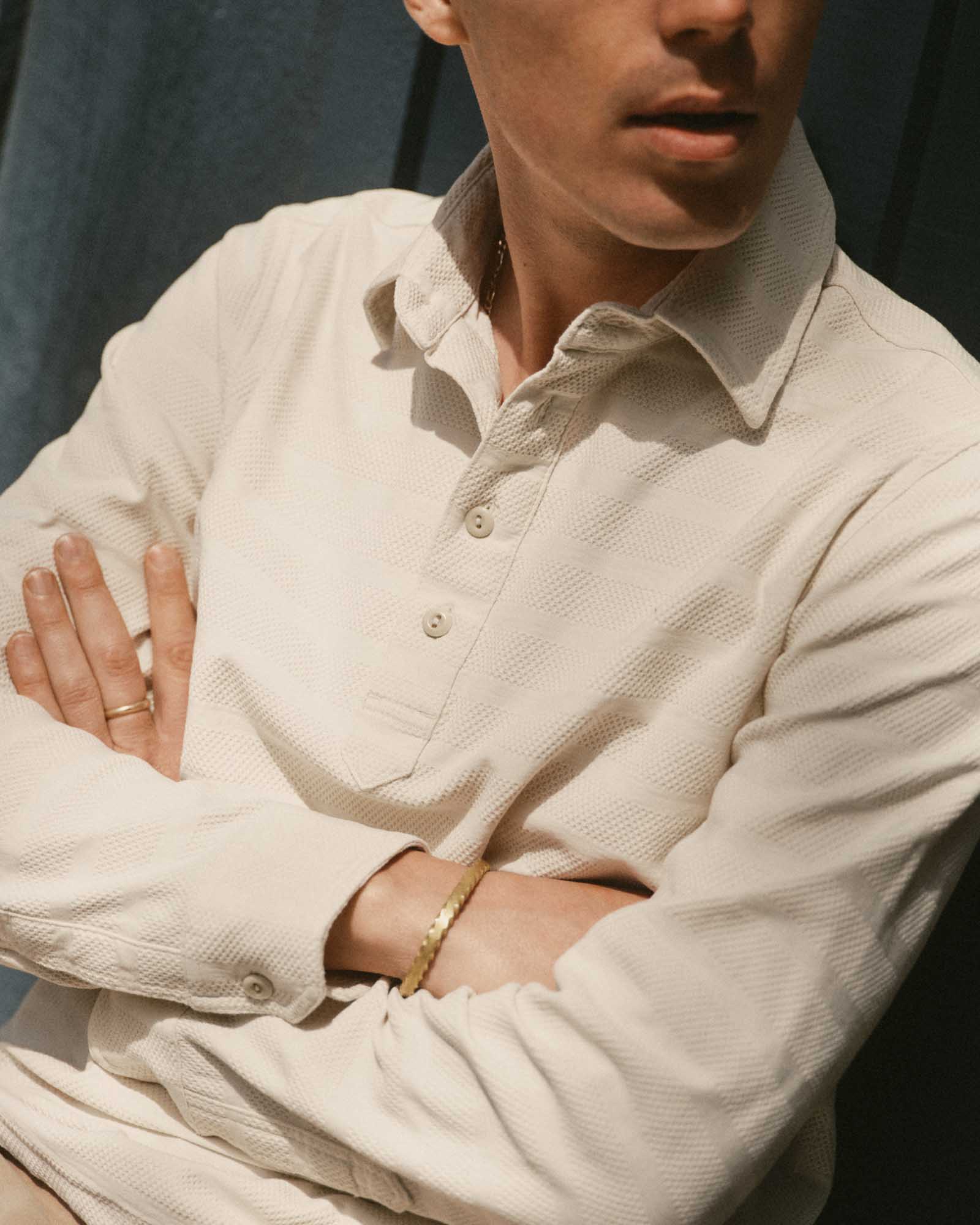 fit model with his arms crossed wearing The Long Sleeve Polo in Vintage White Knit Stripe, Knits by Taylor Stitch