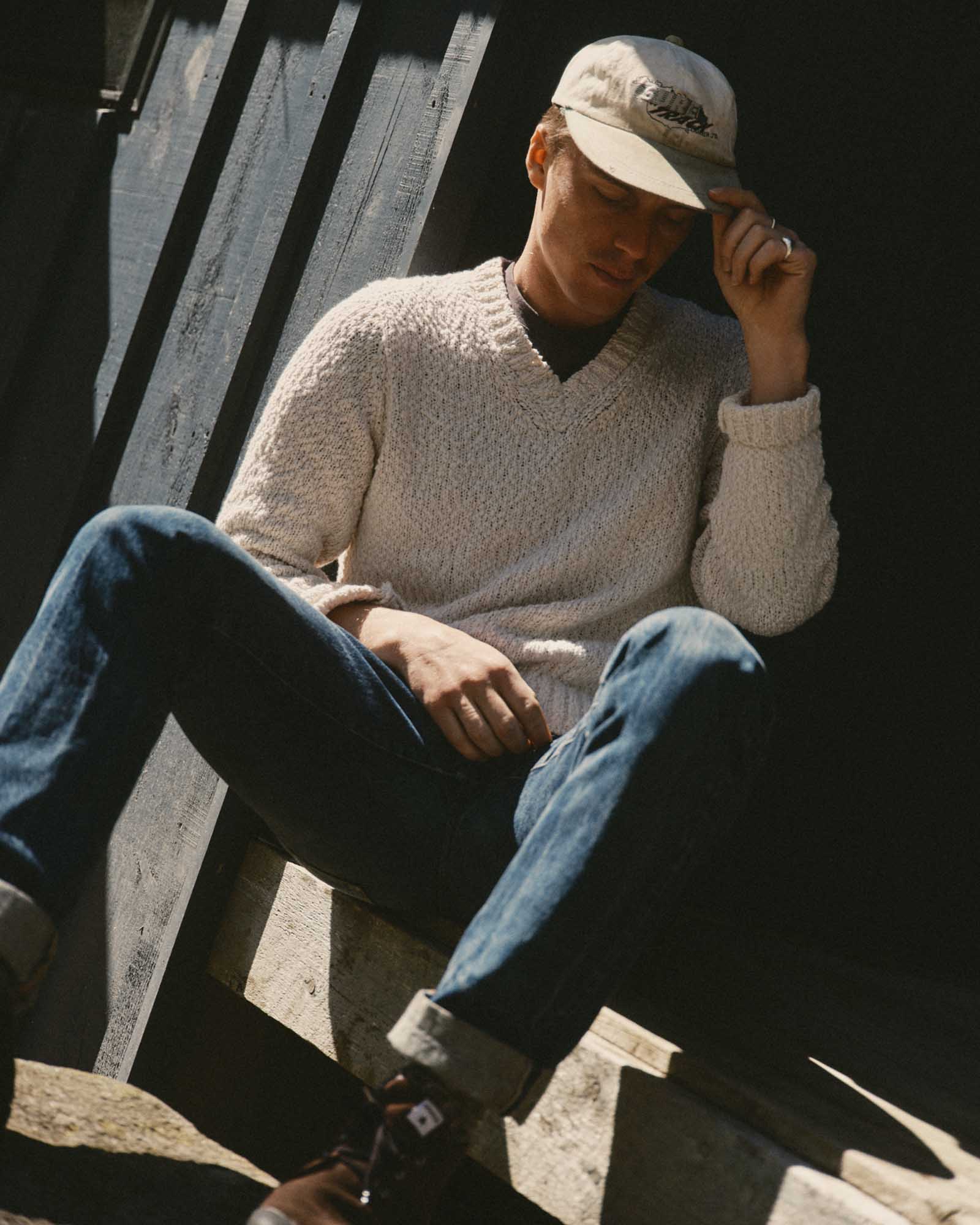 fit model sitting wearing The Match V-Neck Sweater in Vintage White Slub, Knits by Taylor Stitch