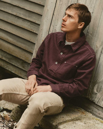 fit model sitting wearing The Milton Overshirt in Burgundy Slub Denim