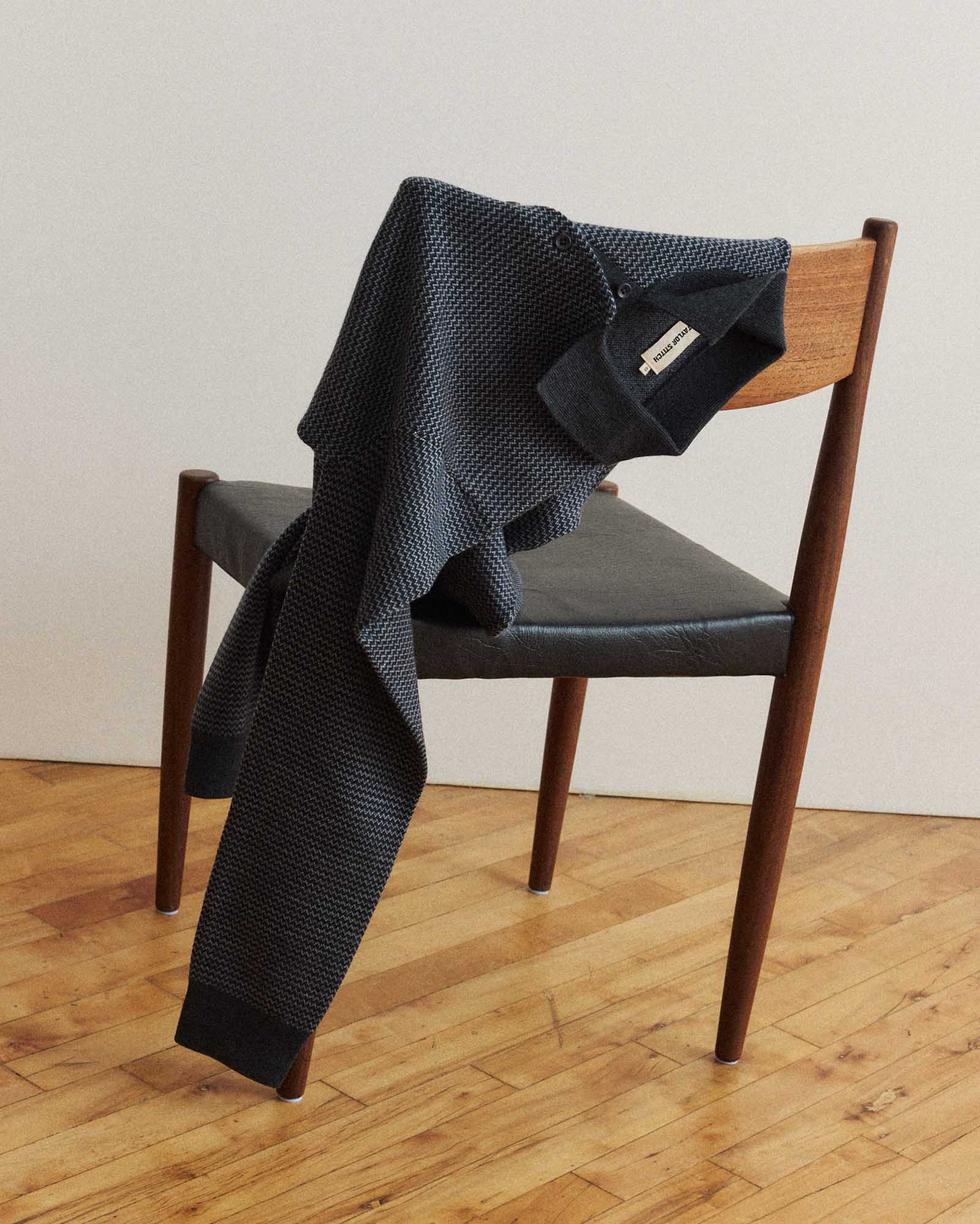 editorial image of The Newton Sweater Polo in Navy Birdseye Merino on a chair, Knits by Taylor Stitch