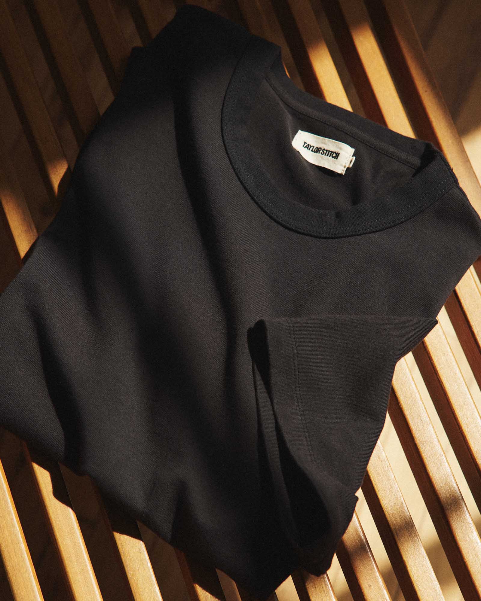 editorial flatlay of The Organic Cotton Shop Tee in Black, Knits by Taylor Stitch