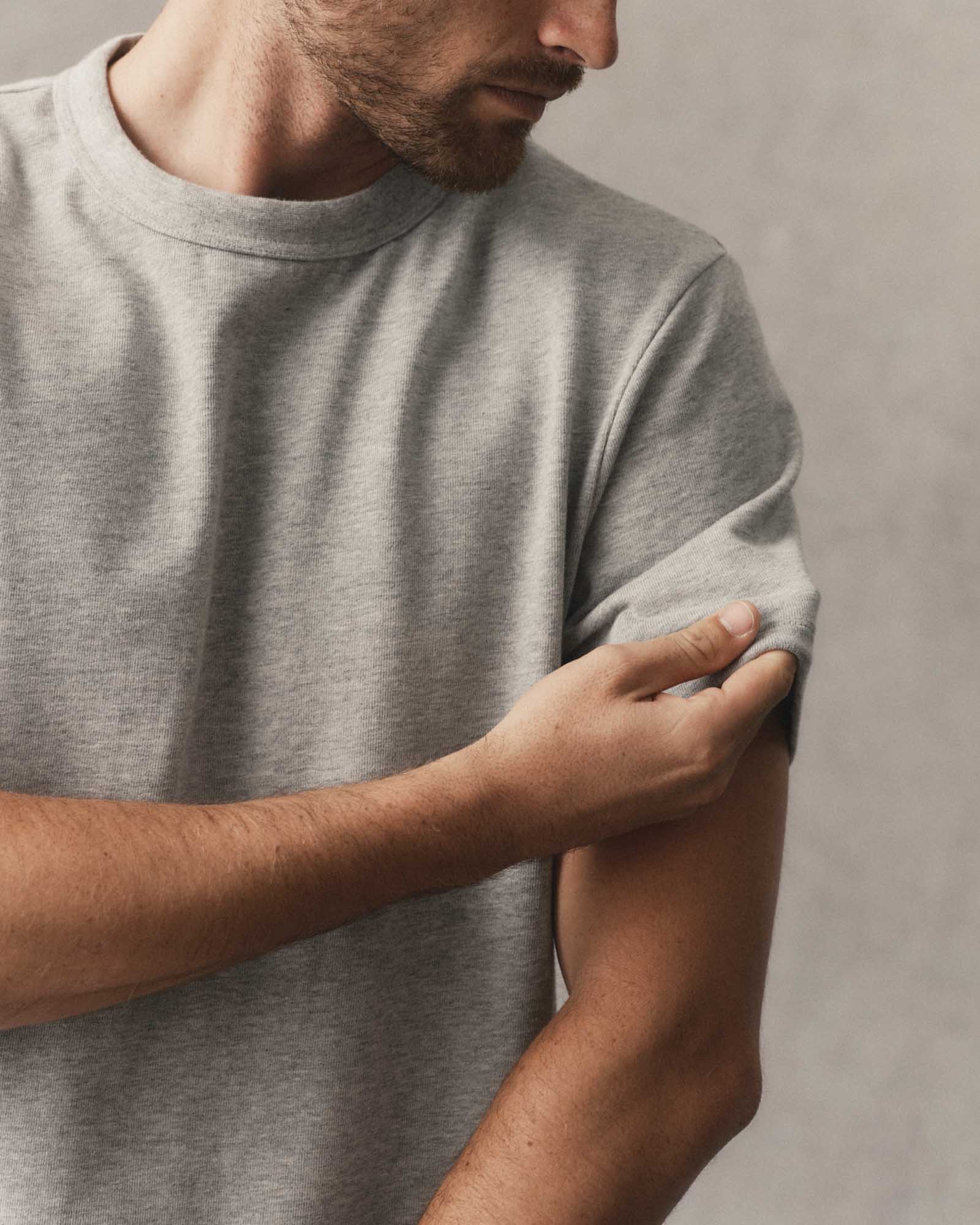 fit model adjusting the sleeves on The Organic Cotton Shop Tee in Heather Grey, Knits by Taylor Stitch