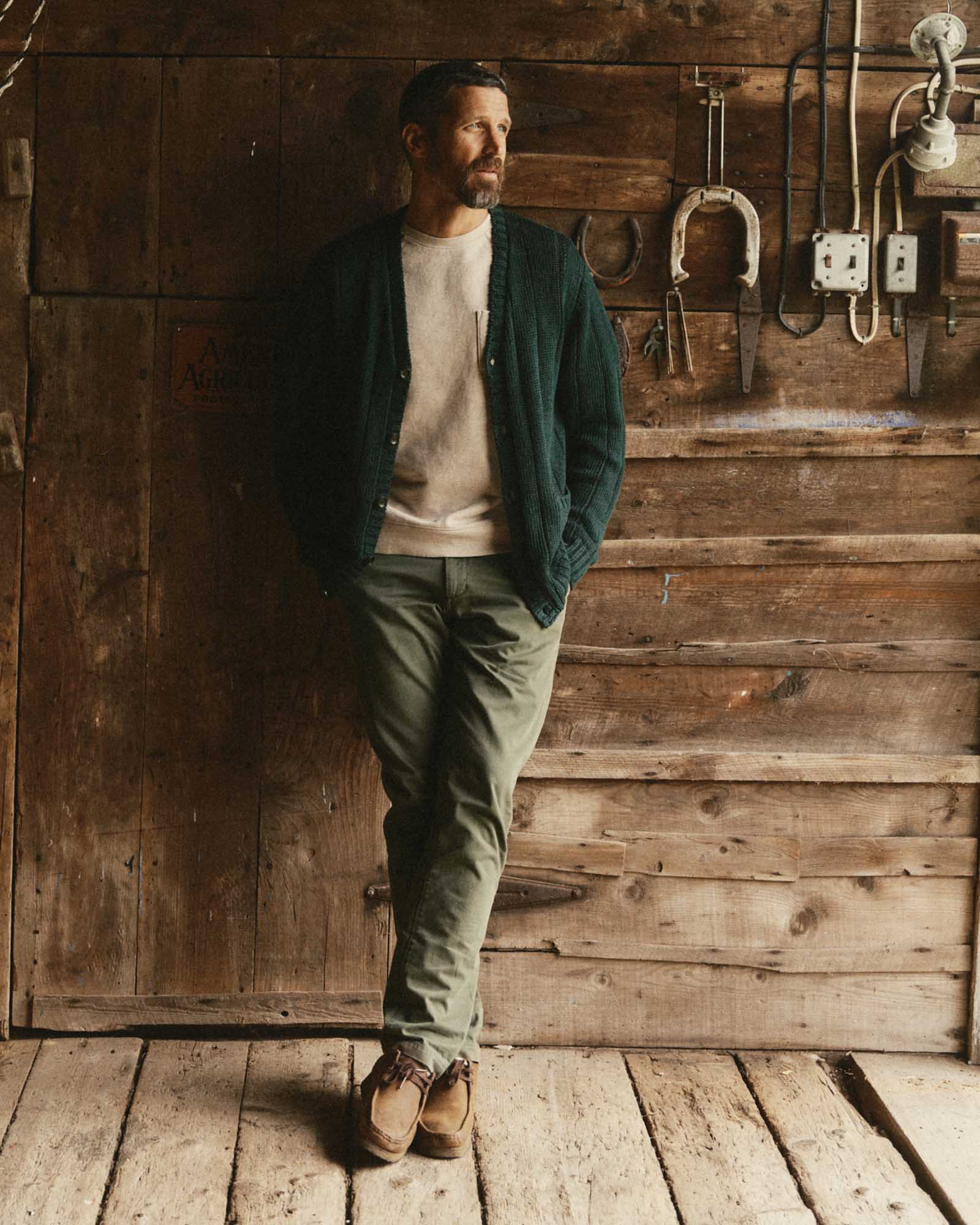 fit model leaning against the wall wearing The Trench Cardigan in Dark Forest Rib Linen, Knits by Taylor Stitch