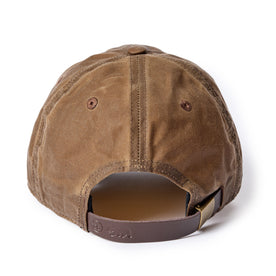 flatlay of The Ball Cap in Dark Khaki Waxed Canvas, showing the leather slide adjustment