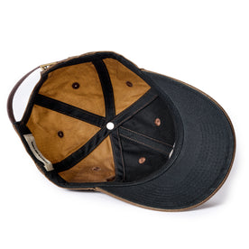 flatlay of The Ball Cap in Dark Khaki Waxed Canvas, showing the underside of the hat