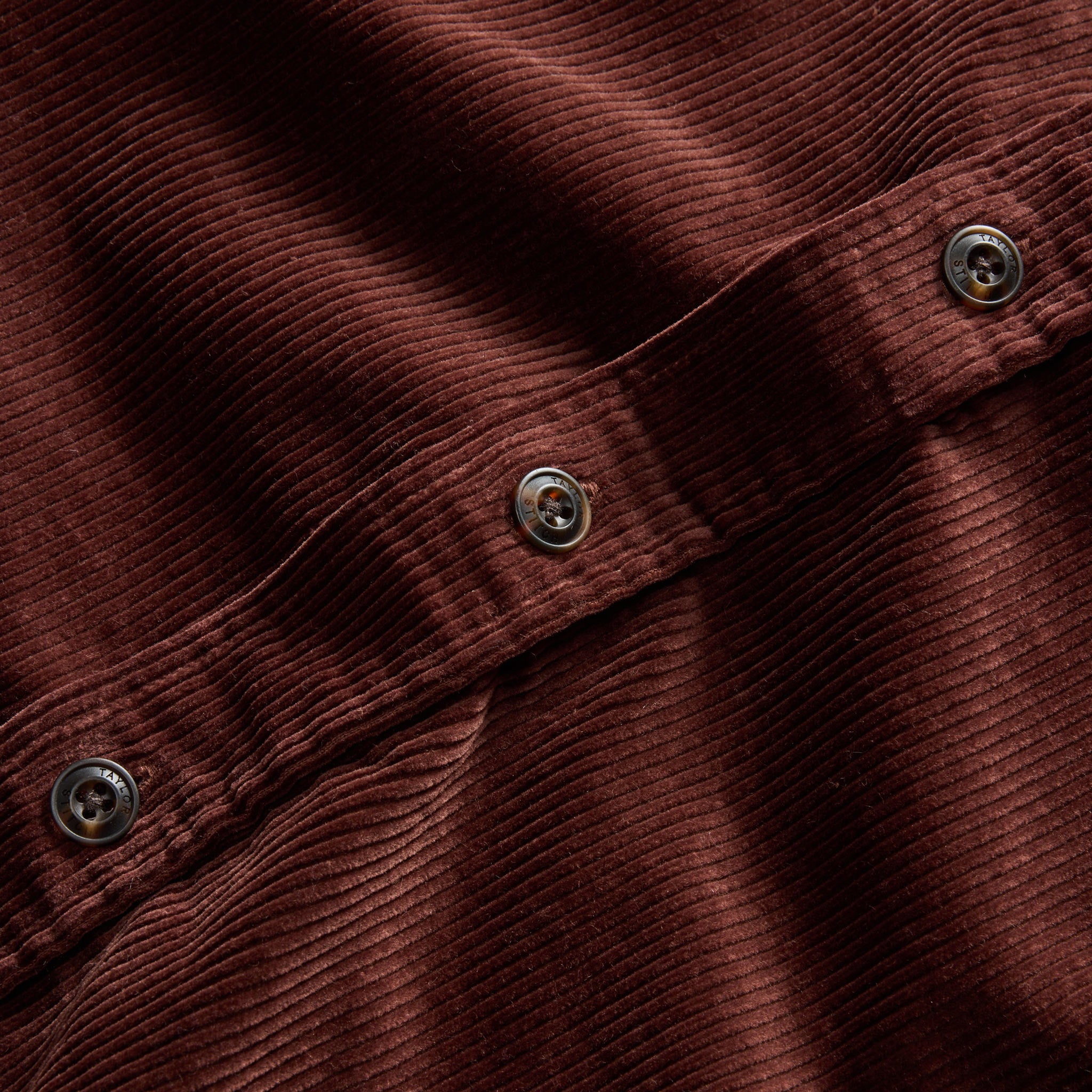 material shot of the dark horn buttons on The Connor Shirt in Burgundy Cord, Wovens by Taylor Stitch