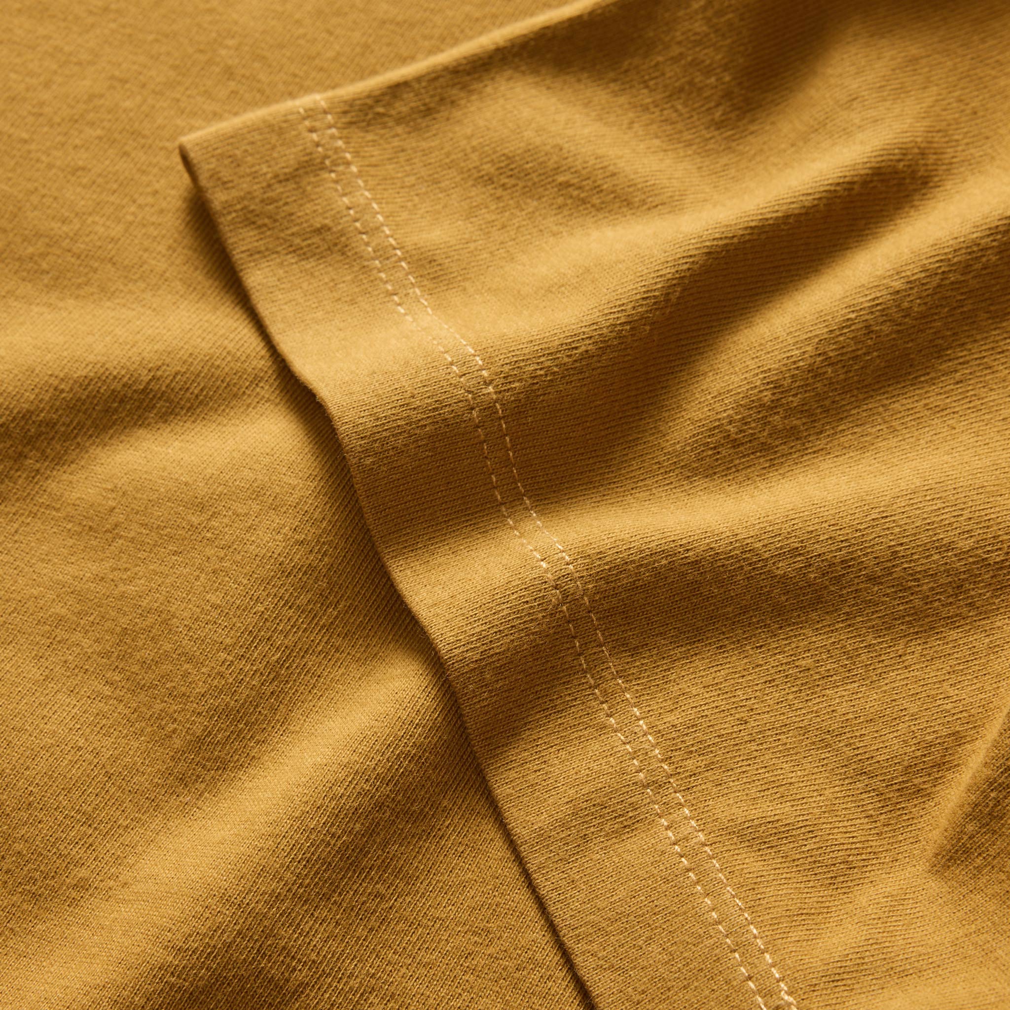 material shot of the sleeves on The Organic Cotton Tee in Old Gold, Knits by Taylor Stitch