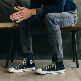 fit model sitting in The Slim Jean in Black 1-Year Wash Selvage Denim