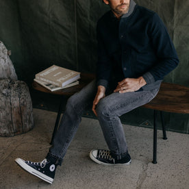 fit model on a bench in The Slim Jean in Black 1-Year Wash Selvage Denim