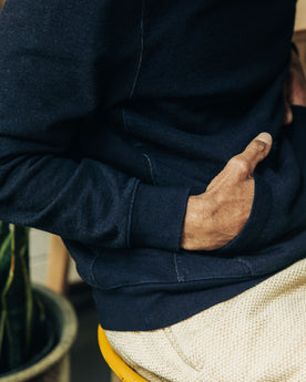 fit model with his hands in the kangaroo pocket of The Apres Hoodie in Indigo Terry, Knits by Taylor Stitch