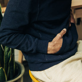 fit model with his hands in the kangaroo pocket of The Apres Hoodie in Indigo Terry