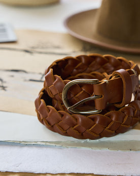 editorial image of The Braided Belt in Whiskey rolled on paper, Accessories by Taylor Stitch