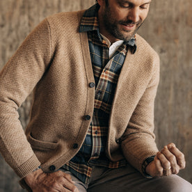 fit model sitting in The Eddy Cardigan in Camel Herringbone Merino