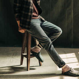 fit model sitting in The Democratic Jean in Black 1-Year Wash Selvage Denim