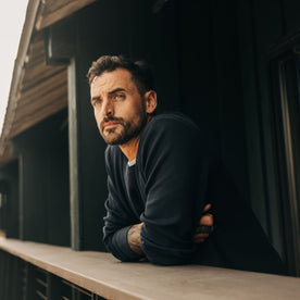 fit model leaning against a balcony in The Organic Cotton Waffle Crew Dark Navy