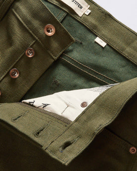material shot of the button fly on The Slim Jean in Olive Nihon Menpu Selvage, Bottoms by Taylor Stitch