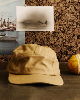 editorial image of The 5-Panel Cap in Khaki Reverse Sateen next to a ball, Accessories by Taylor Stitch