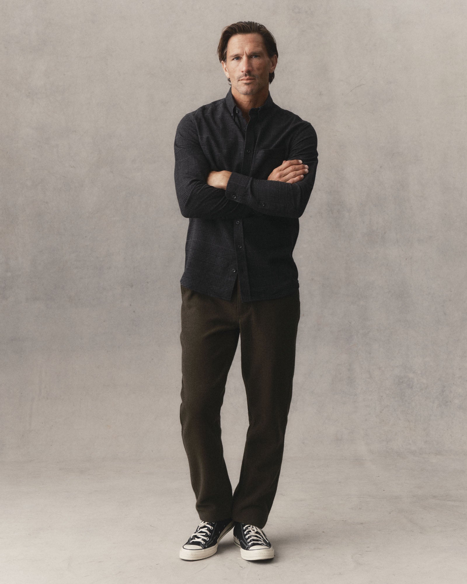 fit model leaning against the wall wearing The Carnegie Pant in Army Herringbone Wool, Bottoms by Taylor Stitch