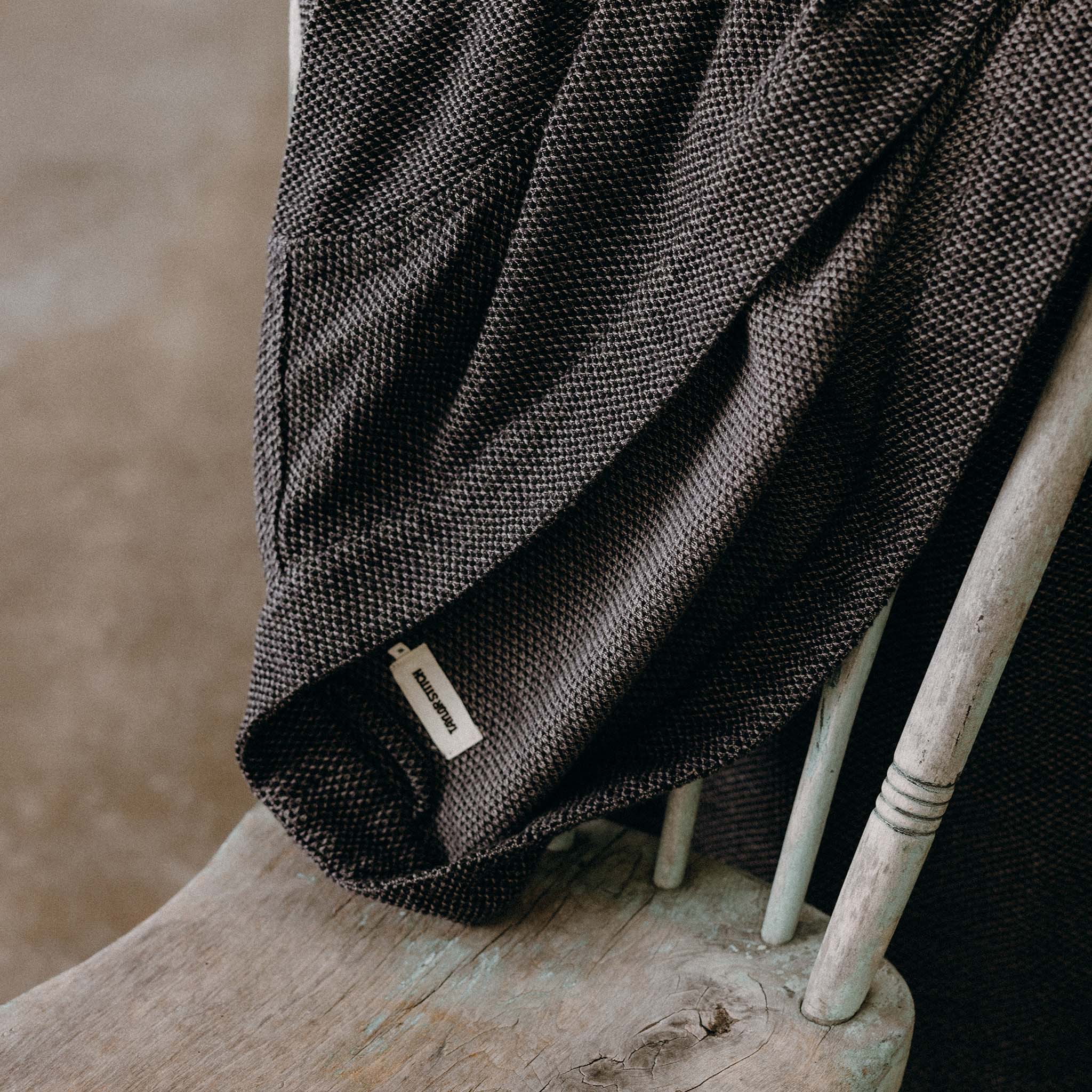 The Apres Robe in Charcoal Sashiko folded on a chair, Accessories by Taylor Stitch