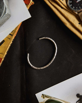 editorial image of The Hammered Cuff in Sterling Silver on a sheet of fabric, Accessories by Taylor Stitch