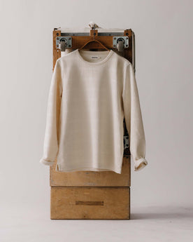 editorial image of The Morgan Crewneck in Natural Slub Stripe on a hanger on a trunk, Knits by Taylor Stitch