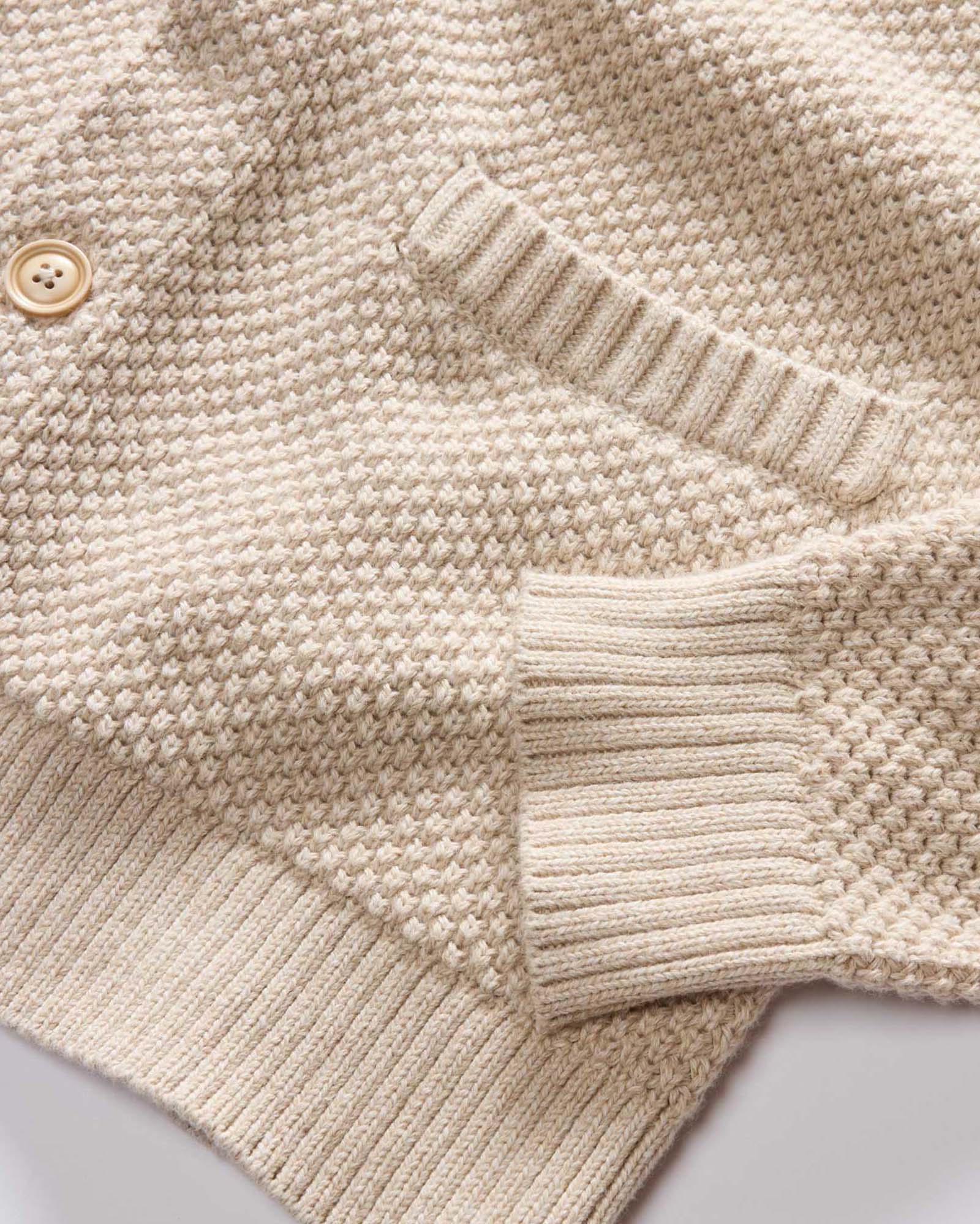 fit model sitting wearing The Crawford Sweater in Marled Natural, Knits by Taylor Stitch