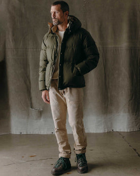 fit model posing in The Down Sweater in Olive Waxed Ripstop, Outerwear by Taylor Stitch