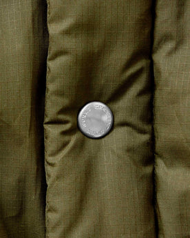 material shot of the buttons on The Down Sweater in Olive Waxed Ripstop, Outerwear by Taylor Stitch