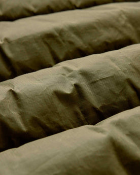 material shot of the fabric on The Down Sweater in Olive Waxed Ripstop, Outerwear by Taylor Stitch