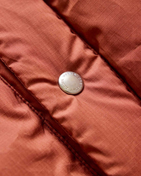 material shot of the button on The Down Vest in Brick Red Waxed Ripstop, Outerwear by Taylor Stitch