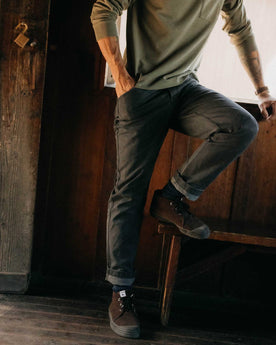 fit model sitting wearing The Camp Pant in Coal Chipped Canvas, Bottoms by Taylor Stitch