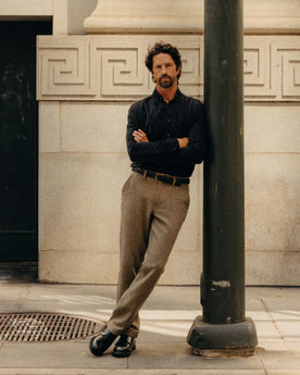fit model leaning against a pole wearing The Carnegie Pant in Gravel Herringbone Wool, Bottoms by Taylor Stitch