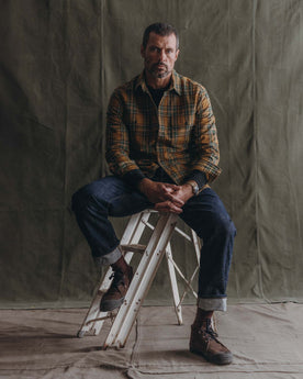 fit model sitting wearing The Craftsman Shirt in Fern Plaid, Wovens by Taylor Stitch