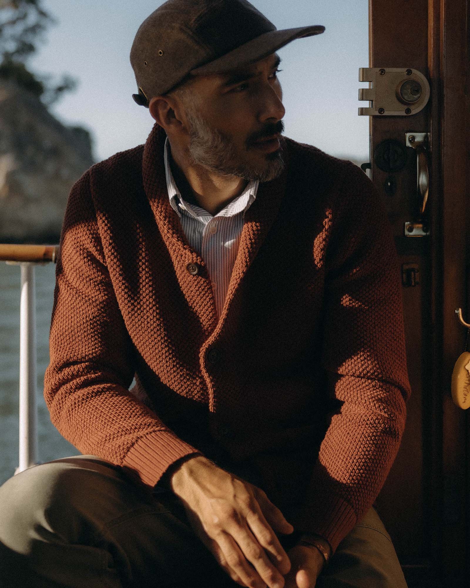 fit model sitting wearing The Crawford Sweater in Rust, Knits by Taylor Stitch